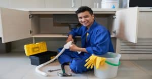Plumber fixing under the sink